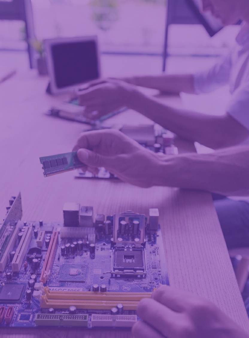 Person holding a computer chip over a motherboard on a desk